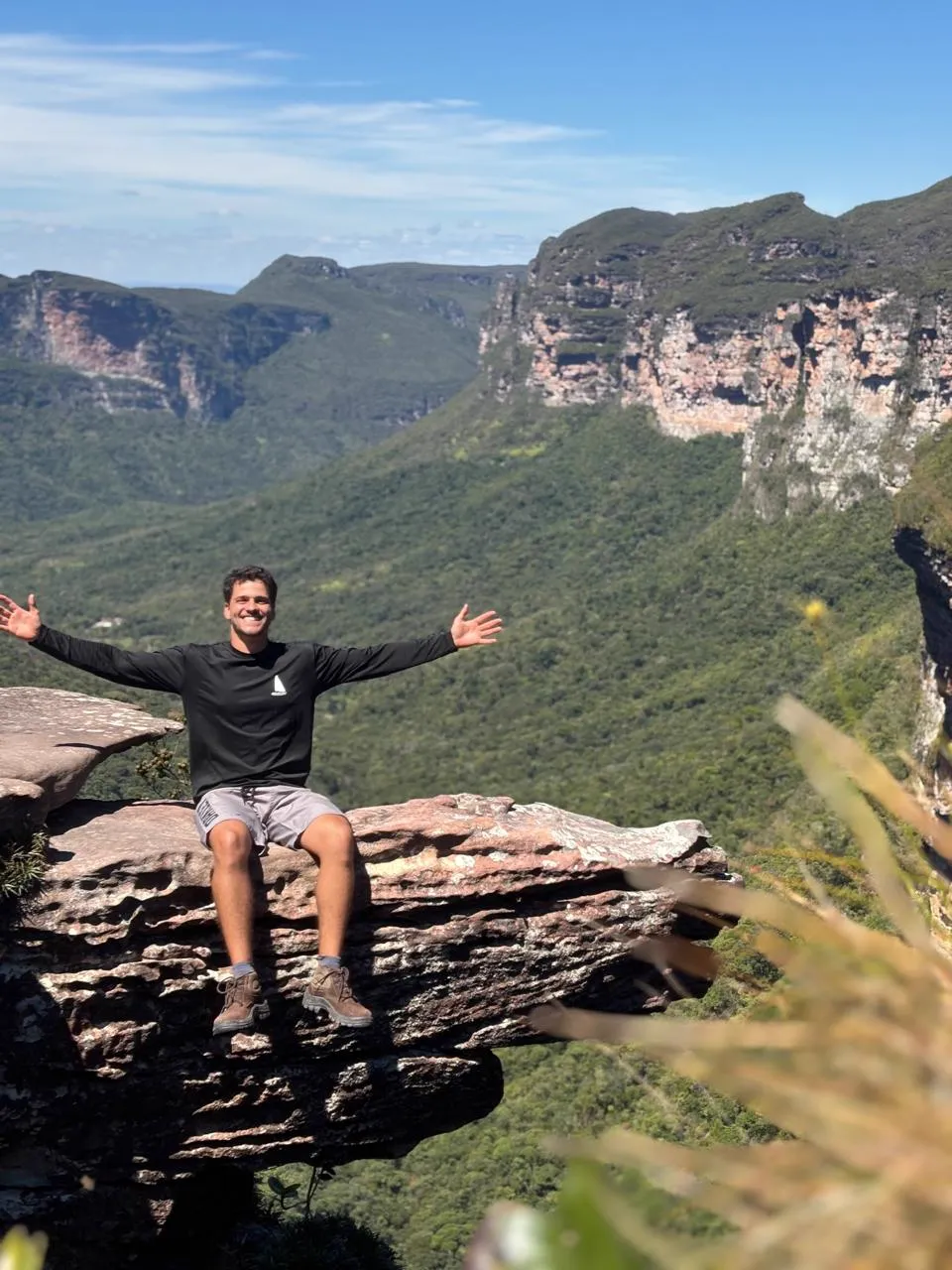 Guia da Mula Trekking sentado em pedra com vista para o Vale do Pati, Chapada Diamantina